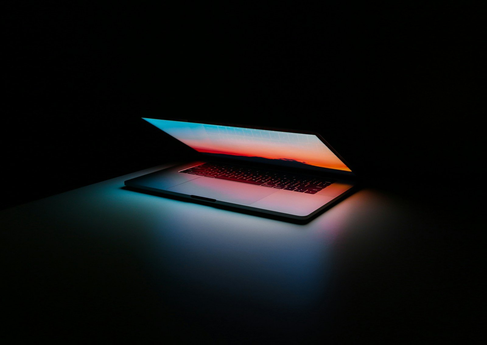 A real laptop photographed against a dark background by Ales Nesetril