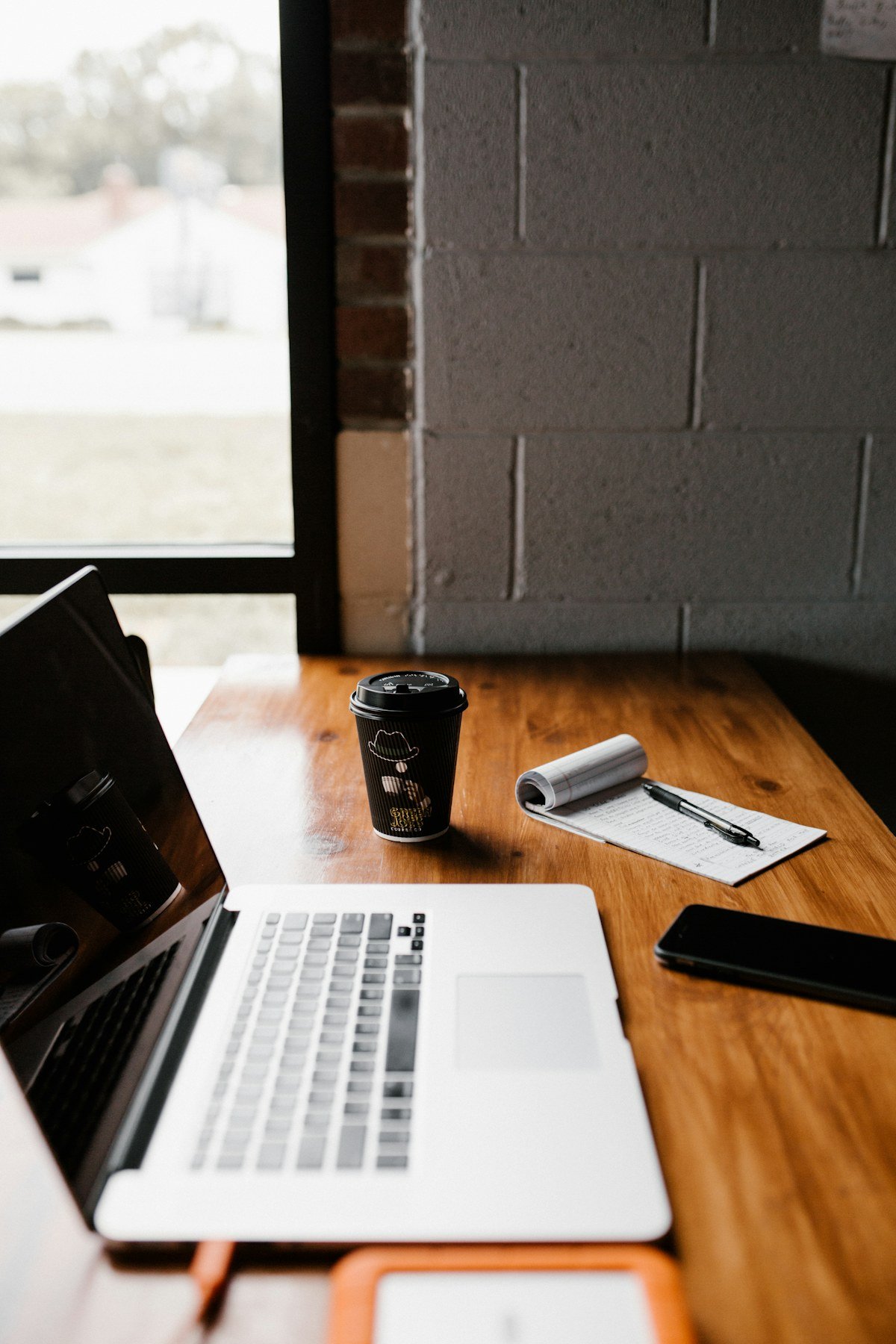 Laptop, coffee and notebook on a wooden workspace